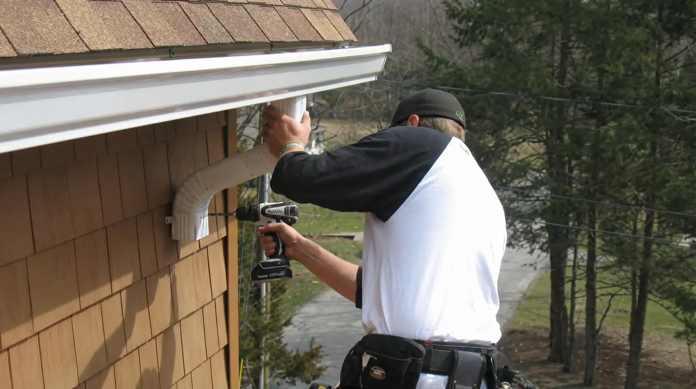Professional contractor installing tan vinyl siding panels on a residential home exterior in Little Rock, AR